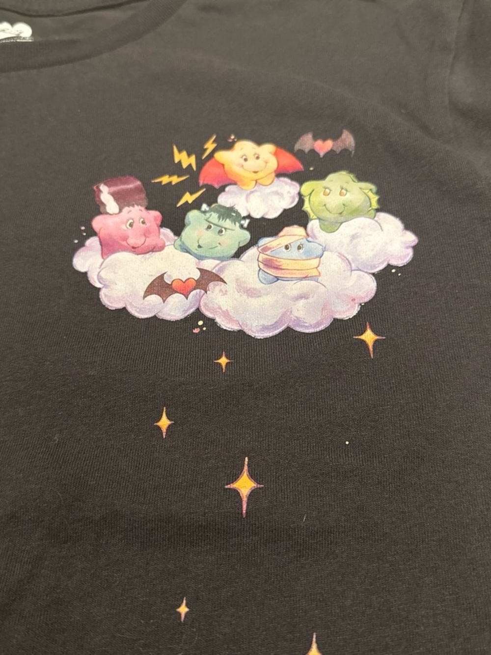 Care Bears Black Tee with Pink, Green, Blue, Yellow and Purple Cloud Characters